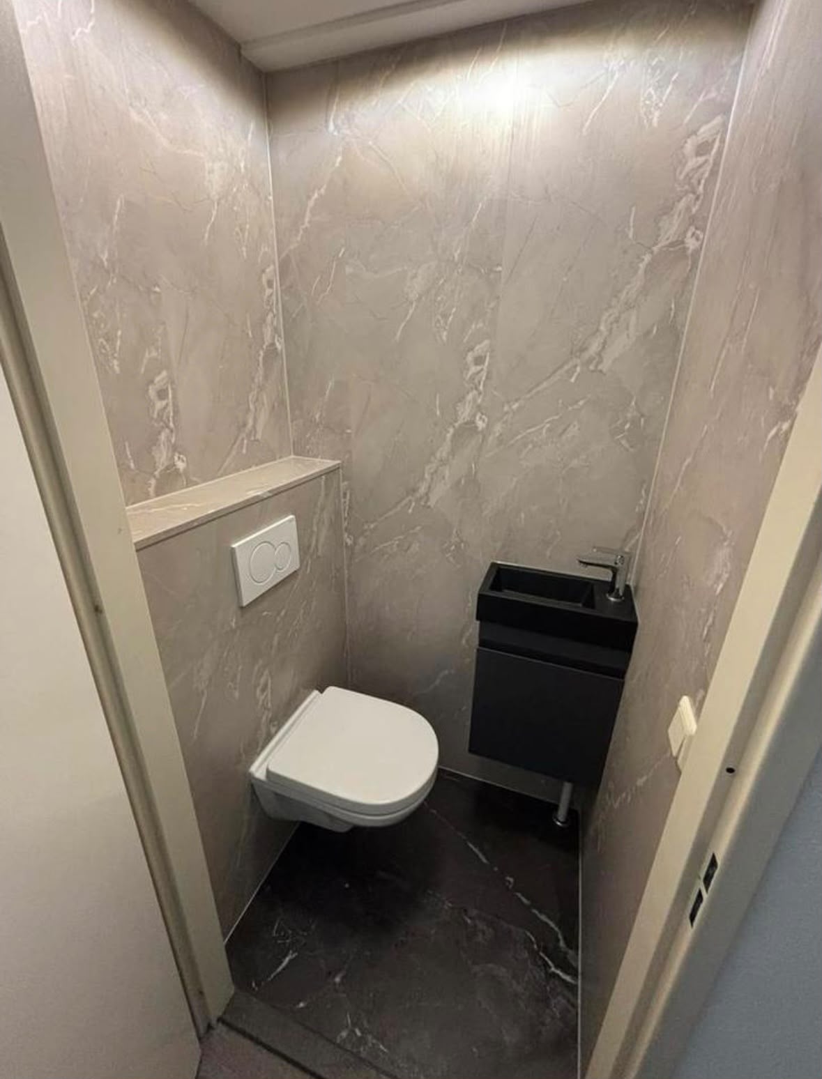 Wc renovatie met marmerlook wandpanelen en mat zwart meubel Wc renovatie met marmerlook wandpanelen en mat zwart meubel
