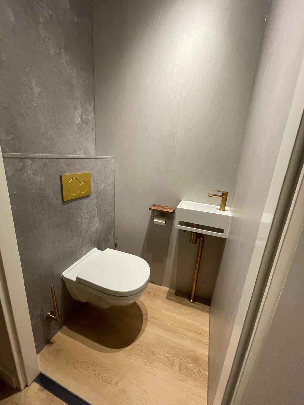 Wc renoveren: gerenoveerd toilet met microcement wand en geborsteld gouden sanitair Wc renoveren: gerenoveerd toilet met microcement wand en geborsteld gouden sanitair